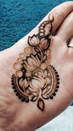 a woman's hand with a henna tattoo on it