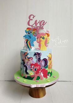 a birthday cake decorated with my little pony and ponies is on a wooden stand