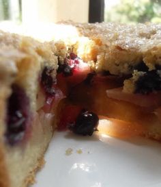 a blueberry pie is cut in half on a white plate with a window behind it