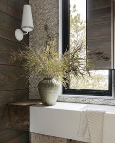 a vase filled with flowers sitting on top of a white shelf next to a window