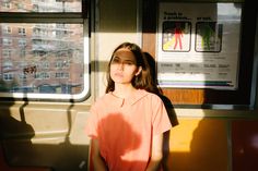 a woman standing in front of a train window