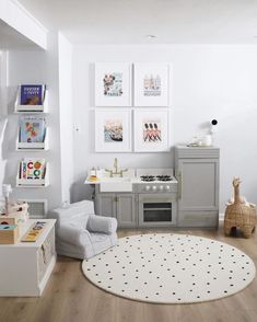 a child's playroom with gray furniture and pictures on the wall above it