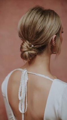 the back of a woman's head with braids in her hair, wearing a white top