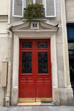 a red door with two windows and shutters