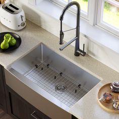 a stainless steel kitchen sink with grid strainer and faucet in the middle