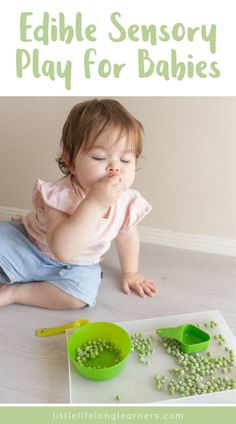 a baby sitting on the floor eating peas