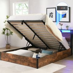 a bed with a wooden frame and mattress in the bottom section is opened to reveal its inner storage compartment