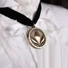 a close up of a person wearing a white shirt with a black ribbon around their neck