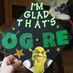 a person holding up a graduation cap that says i'm glad that's ogre