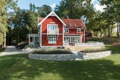 a large red house sitting on top of a lush green field