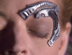 a close up of a person's face with eyeliners made out of metal parts