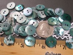 a pile of buttons sitting next to a ruler