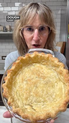 a woman holding up a pie in front of her face