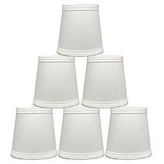 six white lampshades are stacked on top of each other