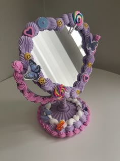 a mirror that is sitting on top of a white table next to a cupcake