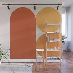 an orange and black wall mural in a living room with a ladder next to it