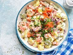 a blue and white bowl filled with food on top of a table