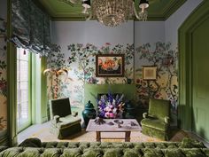 a living room with green walls and floral wallpaper