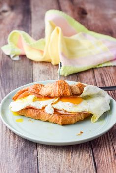 an egg and cheese sandwich is on a plate