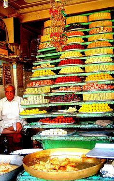 a man sitting in front of a large display of food