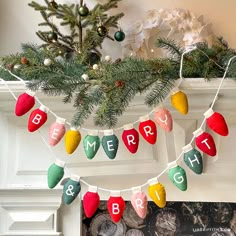 christmas lights hanging from a mantel decorated with evergreen branches and red, green, yellow and white ornaments