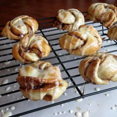 several cinnamon rolls sitting on top of a cooling rack