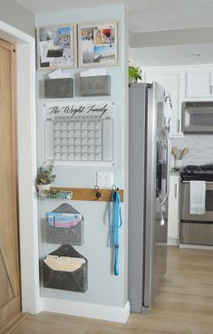 a kitchen with a refrigerator and pictures hanging on the wall above it's door