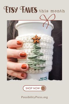 a woman's hand holding a coffee cup with a christmas tree on it