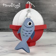 an ornament shaped like a fish on top of a ball