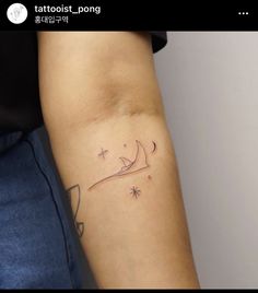 a woman's arm with a tattoo on it that has a boat and stars