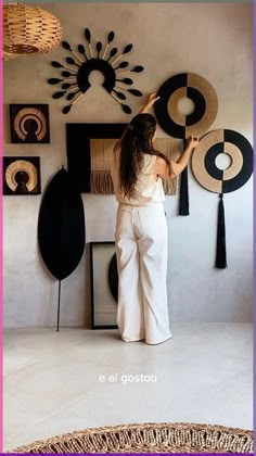 a woman standing in front of a wall with art on it