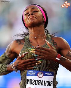 a woman with tattoos on her arm and chest standing in the middle of a race