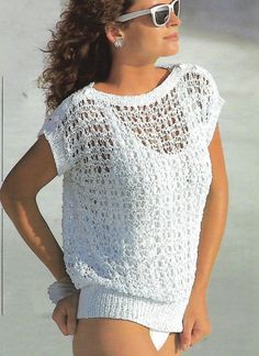 a woman in white is standing on the beach with her hands on her hips and wearing sunglasses