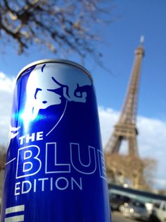 a can of blue beer in front of the eiffel tower