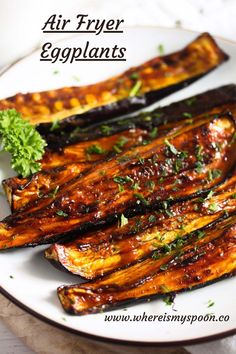 grilled eggplant on a white plate with parsley