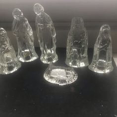 five glass figurines sitting on top of a black counter next to a window