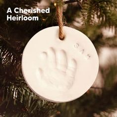 a white ornament hanging from a christmas tree with the words, a cherished heiroom written on it