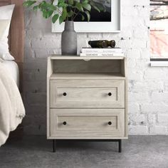 a bedroom with white brick walls and a plant on the nightstand next to the bed