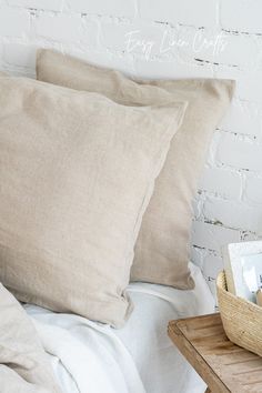 two pillows and a basket on a bed