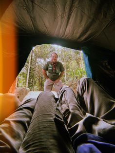 a man is standing in a tent with his feet on the ground