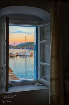 an open window with boats in the water