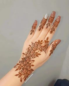 a woman's hand with henna tattoos on it