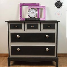 a black and grey dresser with a clock on top