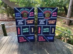 two signs are sitting on a wooden deck