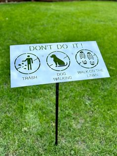 a sign in the grass that says don't do it trash, walk or can't