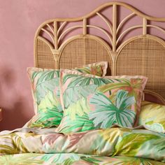 a bed with pink walls and palm leaves on it