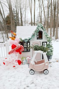 a toy car is parked in front of a house decorated with balloons and garlands