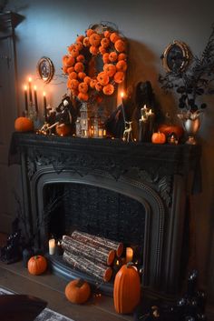 a fireplace decorated for halloween with pumpkins and candles