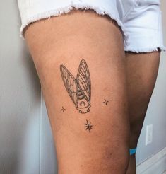 a woman's thigh with a tattoo of a surfboard and stars on it