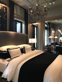 a bedroom with a large bed and chandelier